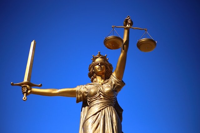 Estátua que simboliza a justiça, cega com uma balança em uma mão e uma espada na outra