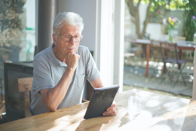 Imagem de um idoso usando tablet