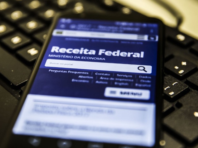 Imagem de um celular sobre um teclado exibindo app da Receita Federal
