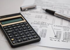 Imagem de calculadora financeira junto com documentos financeiros